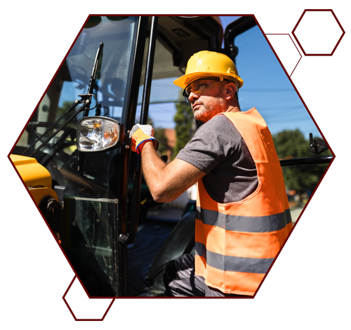 Construction worker climbing into heavy machinery.